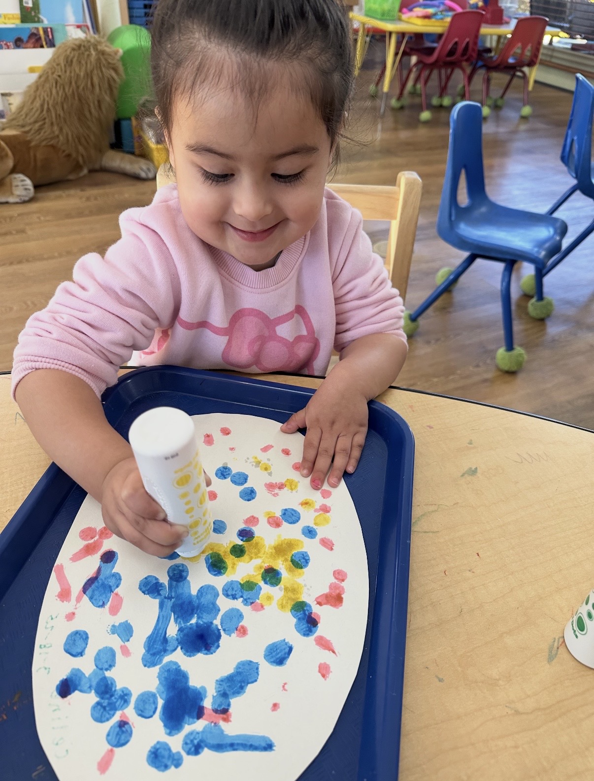 Child using dot markers to paint a colorful picture