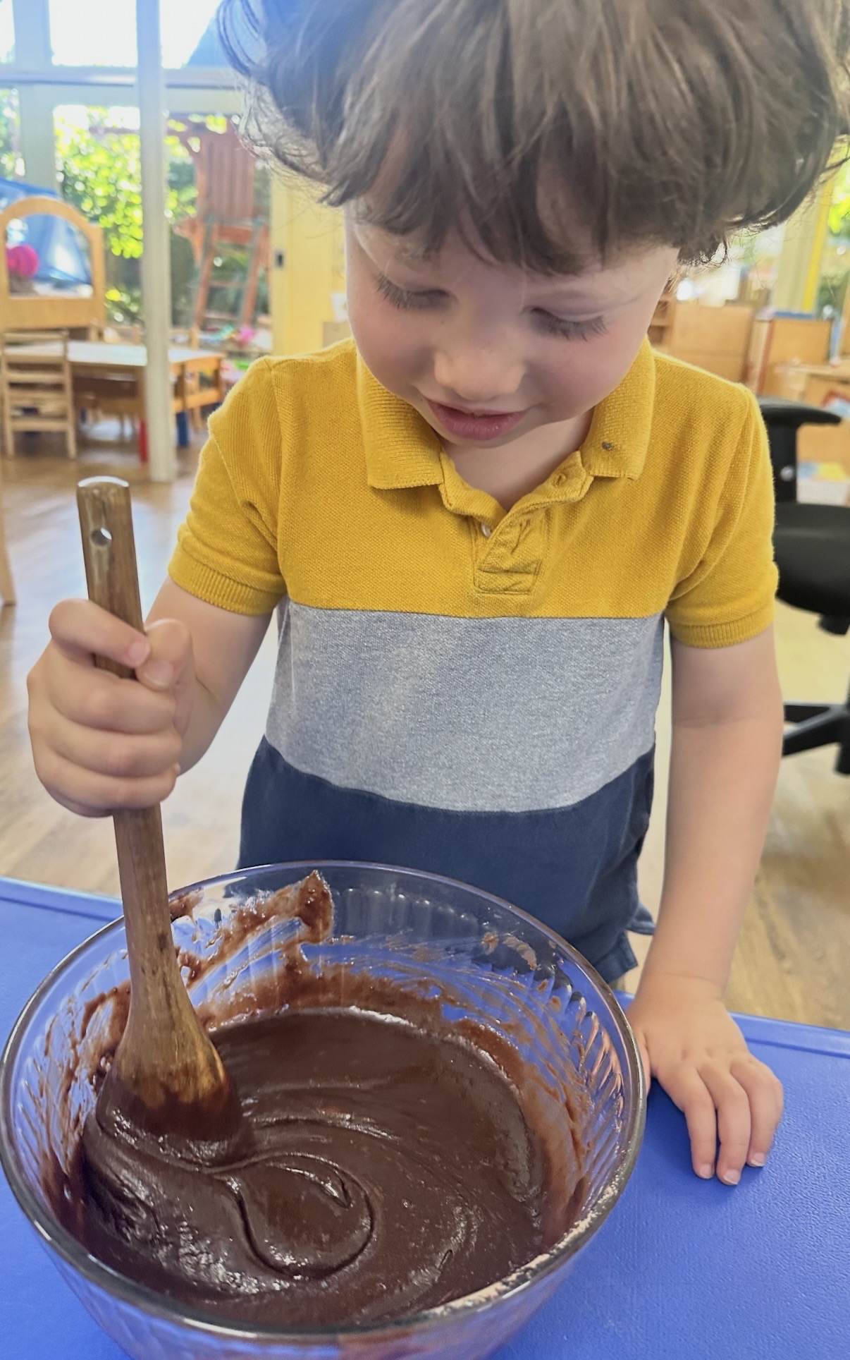 Child stirring batter in a mixing bowl