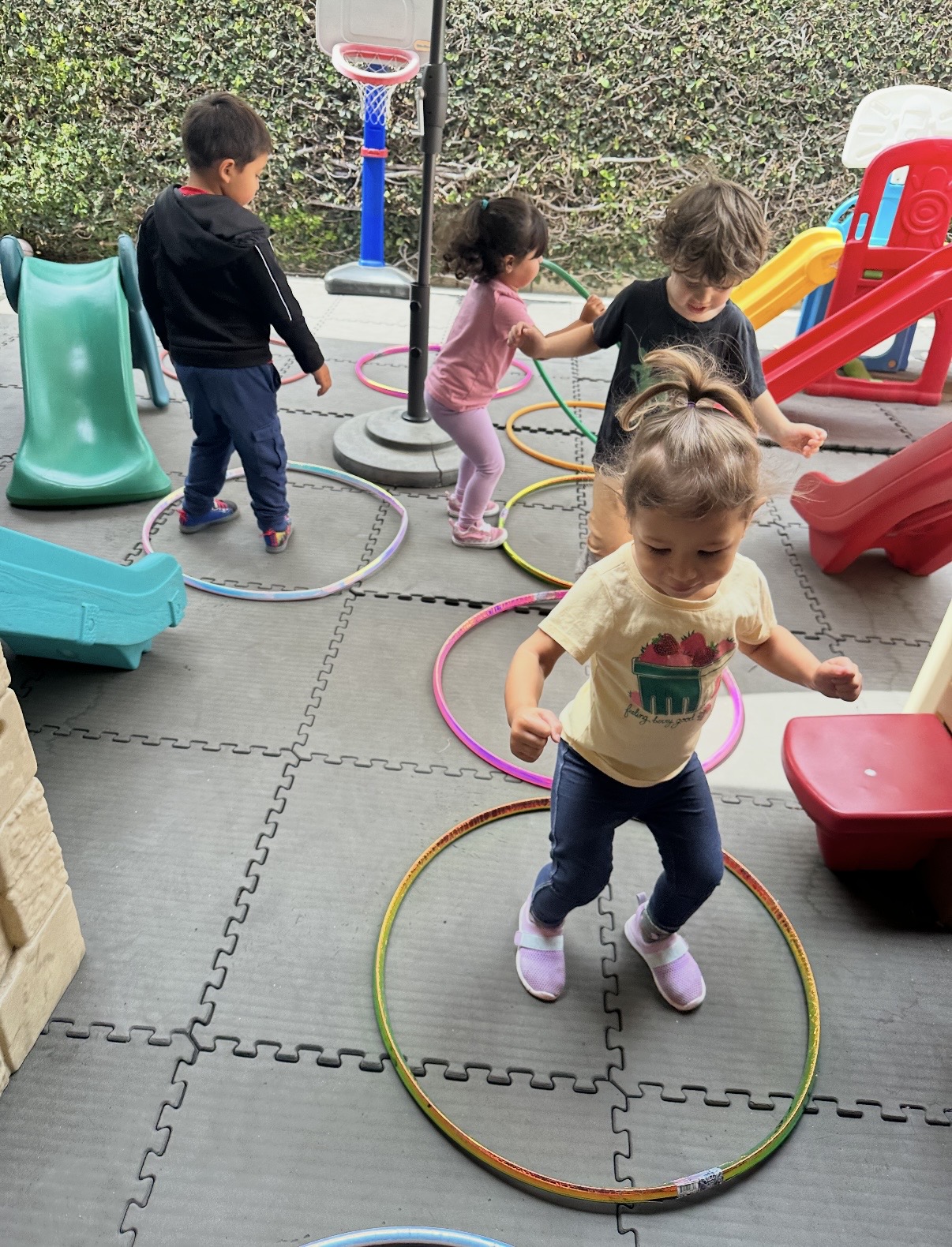 Toddlers moving through hula hoops on the play mat